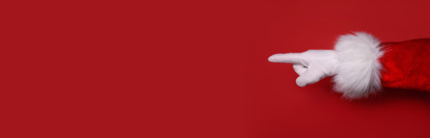 圣诞老人的手指向一个红色的空背景。新年快乐，圣诞快乐!副本的空间。横幅图片下载