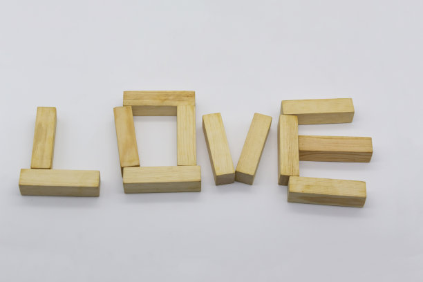白色背景的木块上写着“爱”字。概念可以用在设计上。图片下载