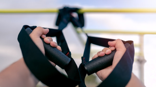 近手运动员工作与TRX系统外。大街上健身房锻炼图片下载