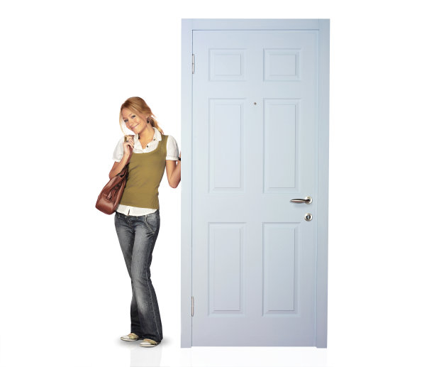 年轻随意的女人站在房子门口图片下载