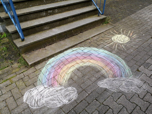 高角度拍摄的彩虹和阳光粉笔画在沥青上图片下载