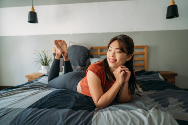 美丽微笑的亚洲女性微笑着躺在她的卧室里图片下载