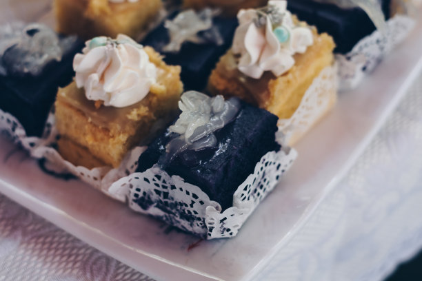 片奶油美味的紫色山药，又名ube蛋糕与macapuno又名椰子运动和柠檬蛋奶蛋糕在白色亚麻布覆盖的桌子上图片下载