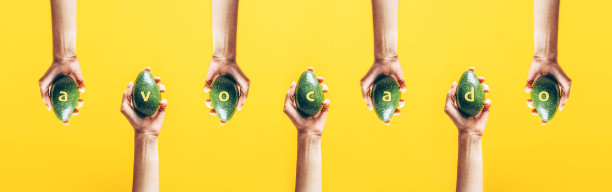 俯视图的妇女手拿牛油果在黄色背景。图片下载