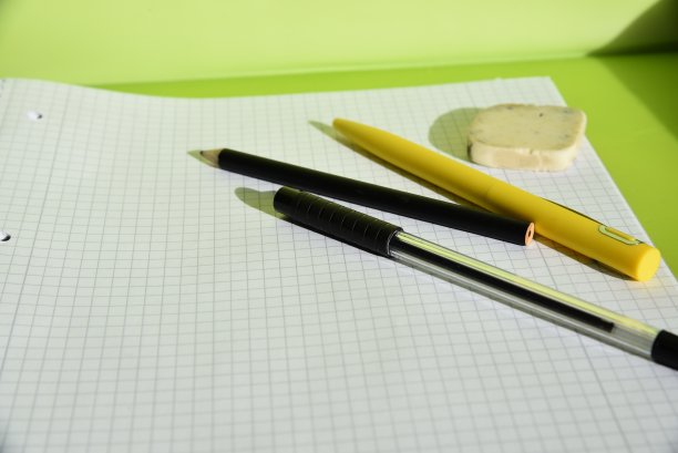 一张有笔和回形针的白色四方纸图片下载