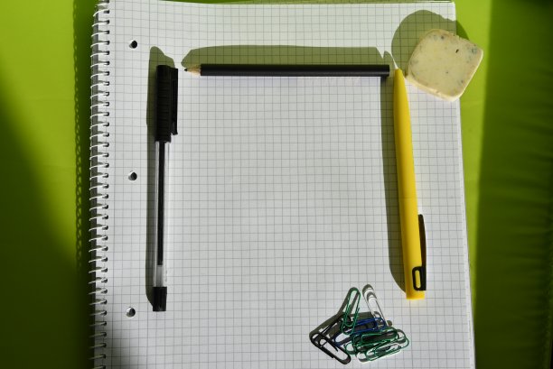 一张有笔和回形针的白色四方纸图片下载