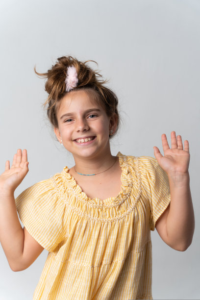 女孩穿着黄色的裙子，脸上带着快乐的表情图片下载