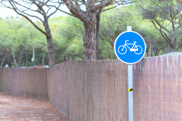 绿色森林中的一条小路上有蓝色的自行车道信号图片下载