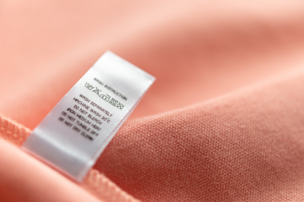 白色洗衣护理洗涤说明衣服标签上的粉红色棉衬衫图片下载