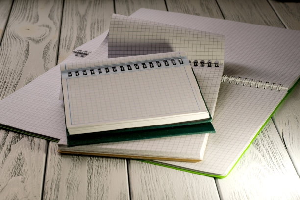 打开的空白笔记本，带有撕下的方格叶子图片下载