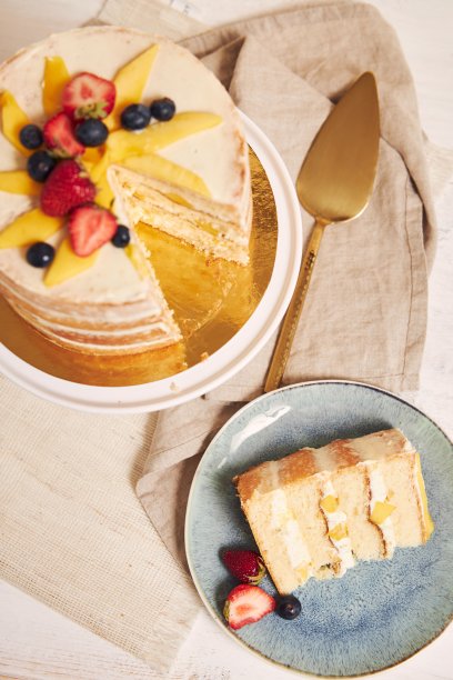 头顶上的美味芒果草莓夏天裸蛋糕在白色的背景与白色的桌子上图片下载