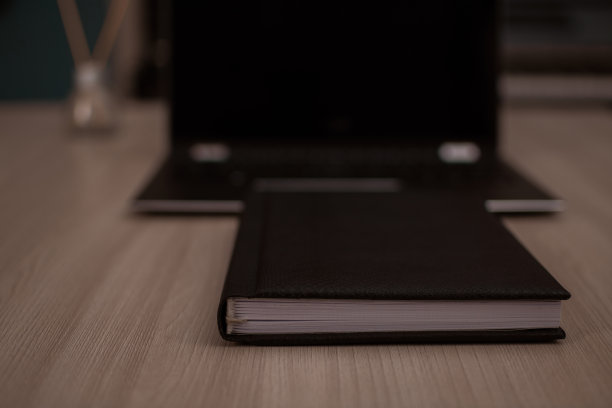 笔记本放在家庭办公室笔记本电脑的前面。图片下载