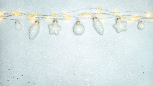 圣诞装饰品挂在花环灯的绳子上，背景是银色的图片下载