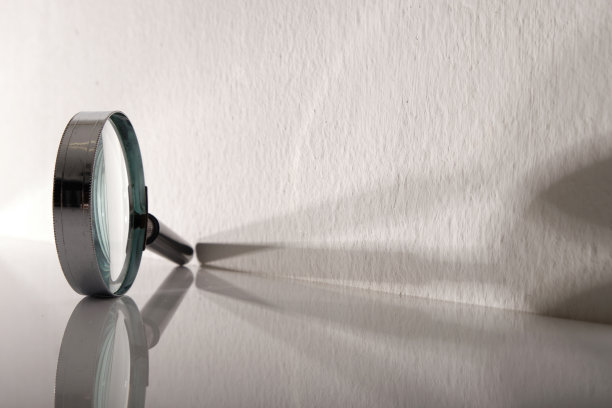 放大镜对着有阴影的白墙图片下载