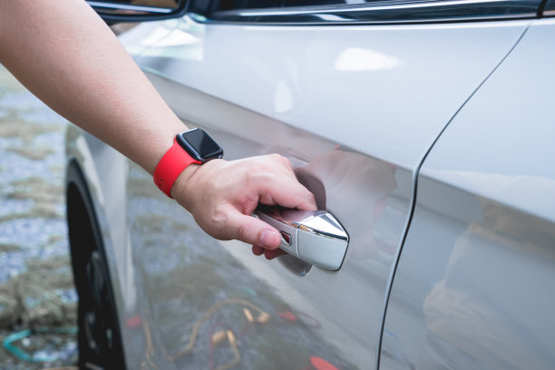 男性手按按钮打开白色车门，关闭。图片下载