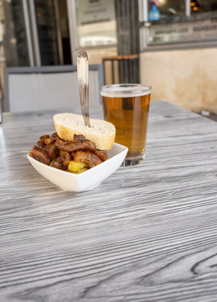 一杯新鲜啤酒的特写照片和一份猪脸的开胃酒。图片下载