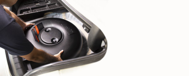 图为，一名机械师正在备胎孔内安装汽车圆形LPG储罐图片下载