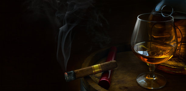 一杯豪华的酒精饮料，一个橡木桶，一瓶干邑和一支雪茄在黑暗的背景;男子俱乐部旗帜与复制空间图片下载