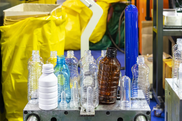 工业中各种样品透明塑料瓶及其他颜色用预制原料放置在制造工艺吹瓶的金属模具上图片下载