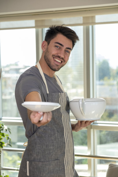 英俊的厨师拿着锅盖对着相机图片下载