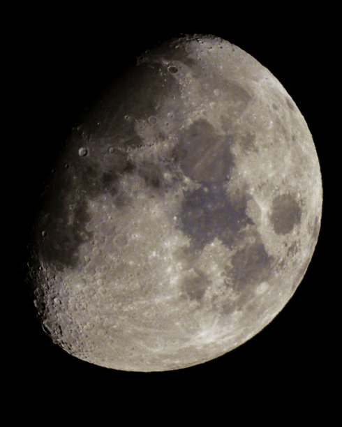 夜晚，月亮在漆黑的天空中垂直拍摄图片下载