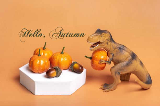 玩具恐龙暴龙拿着南瓜在它的爪子上，在白色的讲台上孤立在橙色的背景节日贺卡万圣节快乐，你好秋天的创意简约概念图片下载