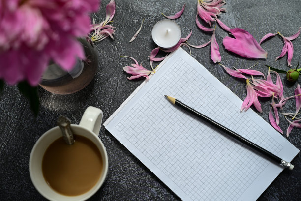 俯视办公室办公桌办公桌。一个有空记事本，文具，铅笔和咖啡杯在黑暗背景下的工作空间。图片下载