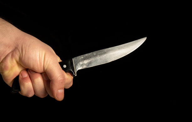 特写男性手握锋利的刀孤立在黑色背景图片下载