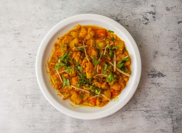 在印度和巴基斯坦德西食物的背景俯视图中，一盘孤立的萨兹薯条或混合蔬菜图片下载