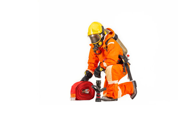 消防队员穿着消防防护服和头盔，配有白色背景的设备和配件，是消防安全事故防护。图片下载