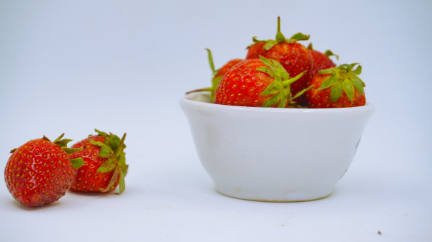 新鲜成熟的美味草莓放在白色的碗里图片下载