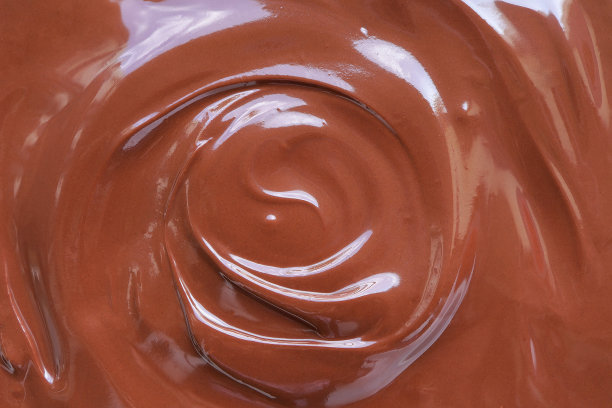 美味的巧克力融化。融化的巧克力漩涡背景。巧克力表面，融化优质巧克力漩涡。图片下载