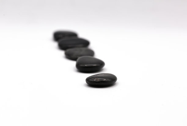 一排排平坦的黑色石头孤立在白色背景上图片下载
