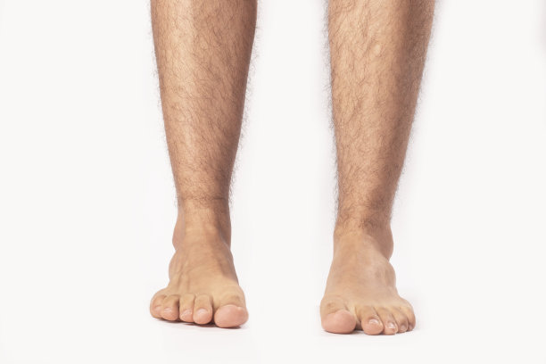 一个成年男子站在白色背景下的脚的特写图片下载