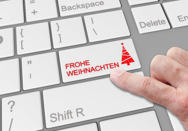有人在笔记本电脑键盘上点击一个特殊的“圣诞快乐”按钮图片下载