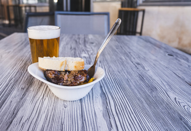 一杯新鲜啤酒的特写照片和一份猪脸的开胃酒。图片下载