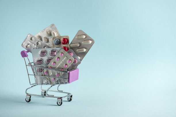 购买药物的概念：蓝色背景篮子里的胶囊和药品图片下载