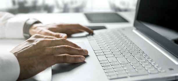 商务人士在明亮的现代办公室里用手提电脑打字。带有复制空间的横幅图片下载