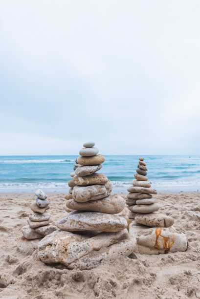 在海滩上，垂直的鹅卵石互相堆叠，保持平衡图片下载