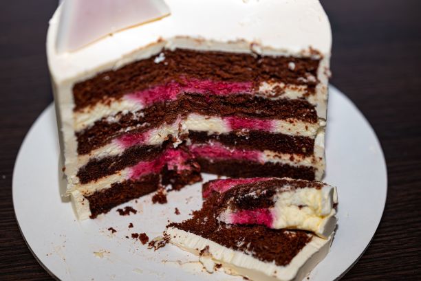 切猫巧克力和樱桃生日蛋糕与白色糖衣木桌背景图片下载