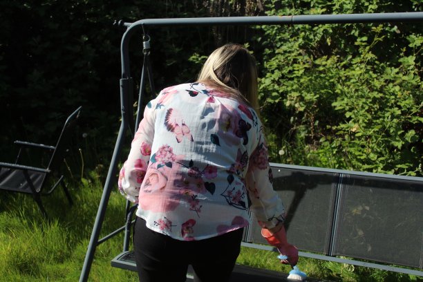 在客人到来之前，一位妇女正在清洁她的花园家具图片下载