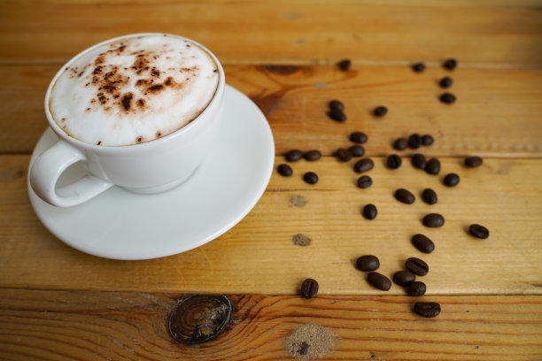 热卡布奇诺在白色杯子木制背景，咖啡是一种受欢迎的饮品在世界各地。图片下载