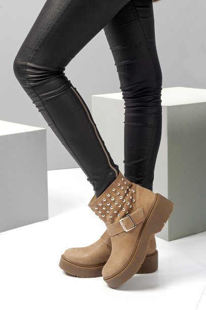 垂直拍摄的站着的女性腿与黑色紧身裤和棕色靴子图片下载