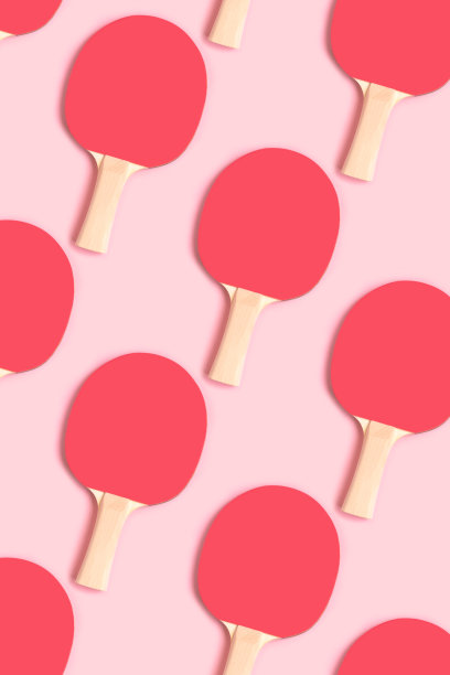 红色网球拍在粉红色的背景上重复的图案。图片下载