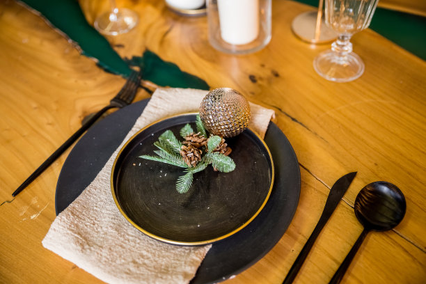 圣诞餐桌布置。黑色餐具和装饰用杉树树枝。平铺，俯视图。除夕夜优雅的餐桌摆设。节日庆祝桌。图片下载