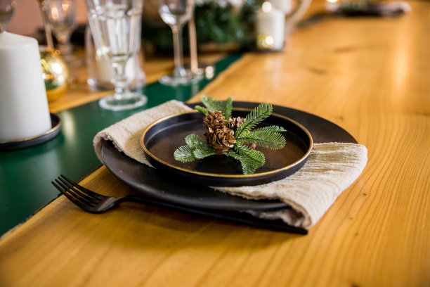 圣诞餐桌布置。黑色餐具和装饰用杉树树枝。平铺，俯视图。除夕夜优雅的餐桌摆设。节日庆祝桌。图片下载