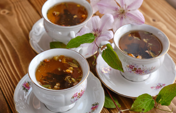 木桌上装有鲜花的茶杯美学照片图片下载