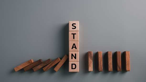 木块支架阻止多米诺骨牌企业危机效应，降低可能的风险。保险,稳定支持。企业利益的法律保护。良好的投资环境。金融的枕头图片下载