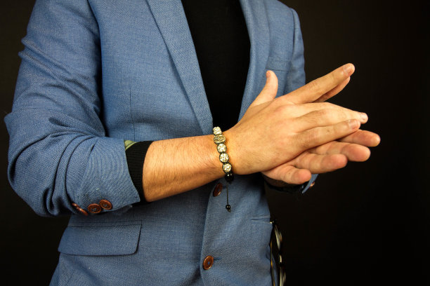 一个穿着西装戴着漂亮石头手镯的男人的特写镜头图片下载