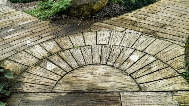 瓷砖混凝土人行道在花园的交叉角度。公园内的瓷砖水泥石地面走道。图片下载